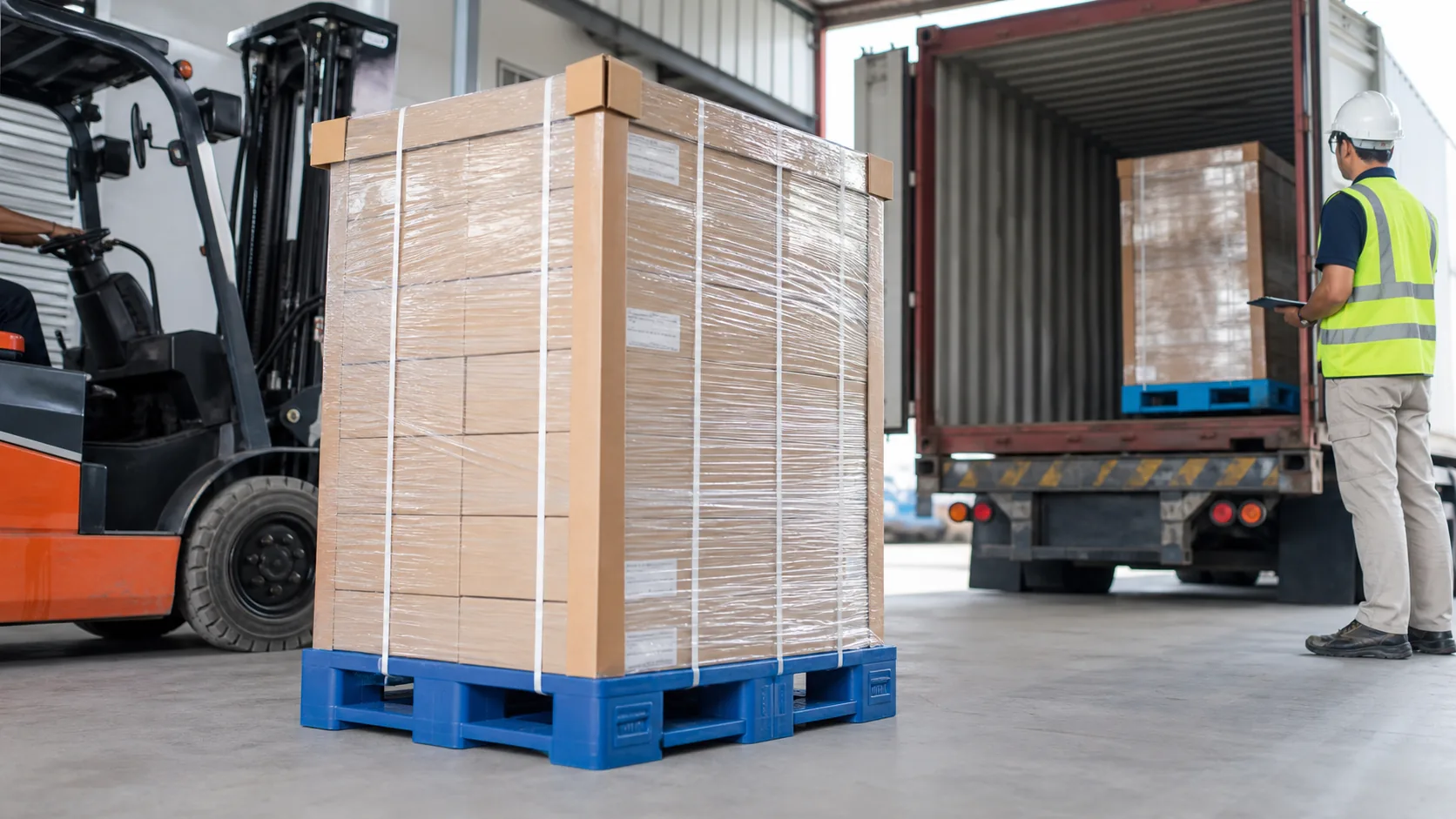 Cartons filmes sur palettes plastiques bleues controles pour stabilite de charge sur un quai de chargement